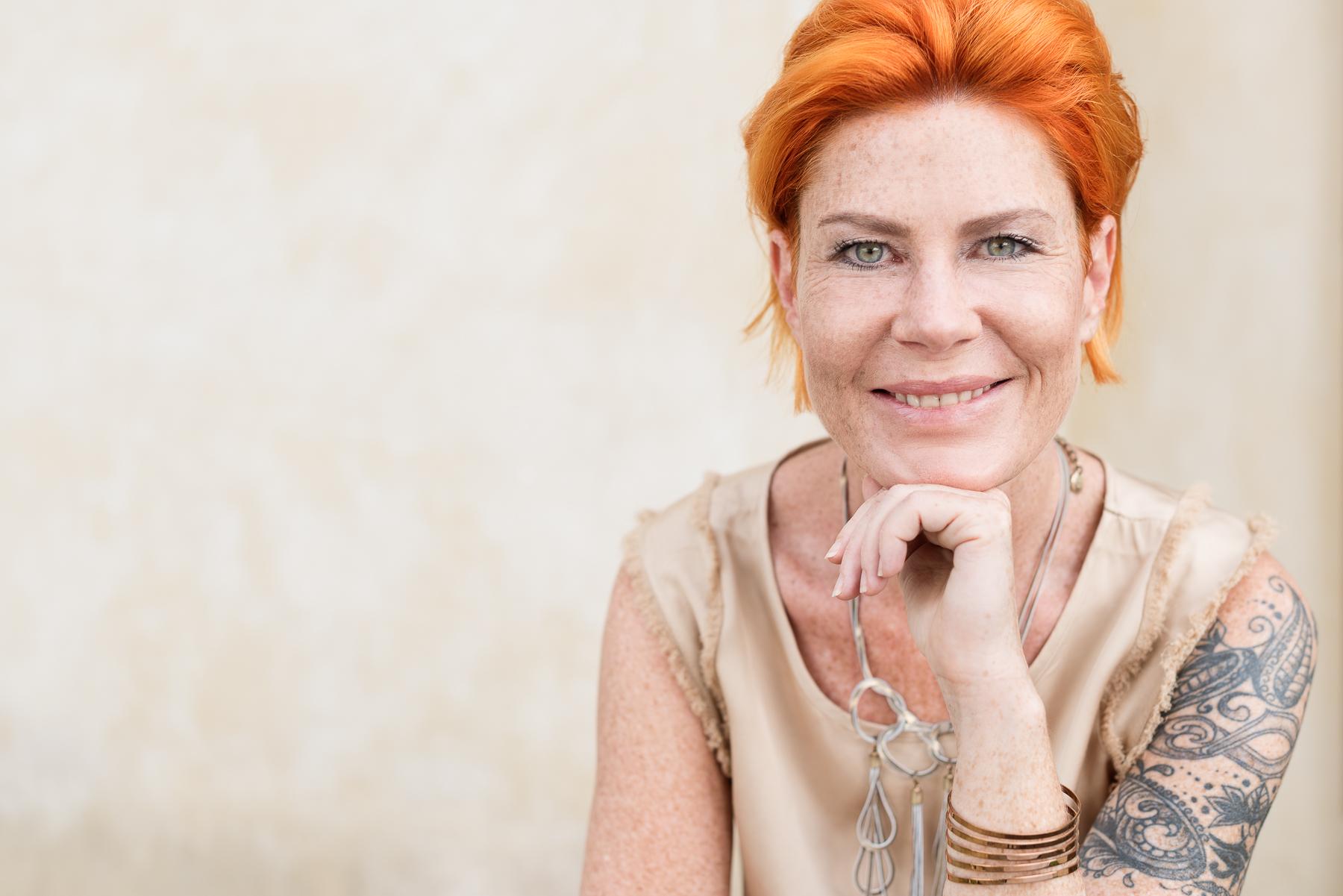 Dame mit orangen Haaren, lächeln, Tattoo, Fokussierung, Schmuck, Strahlen